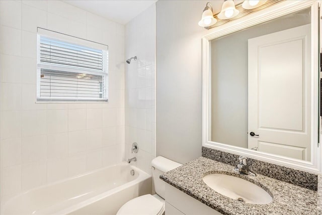 full bathroom featuring vanity, tiled shower / bath, and toilet