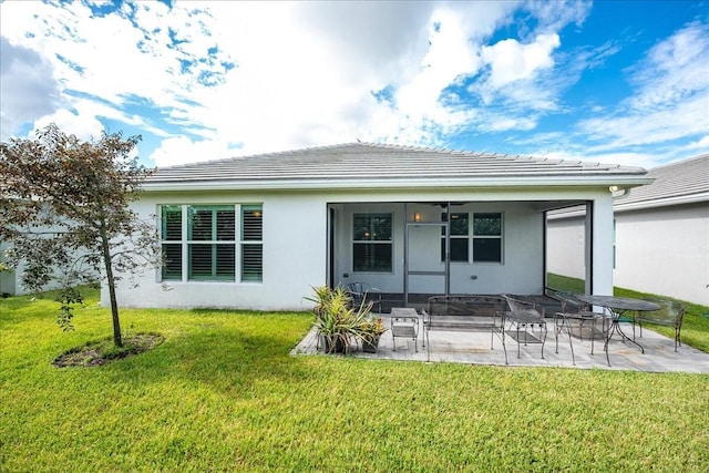 back of house with a patio area, stucco siding, a tiled roof, and a lawn