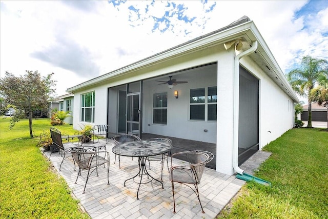 back of property featuring a yard, a ceiling fan, and a patio area