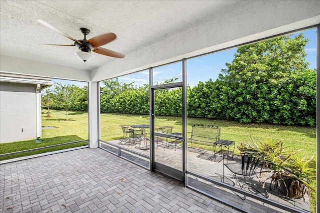 unfurnished sunroom with ceiling fan