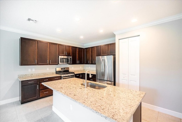 kitchen featuring light stone counters, sink, stainless steel appliances, and a kitchen island with sink