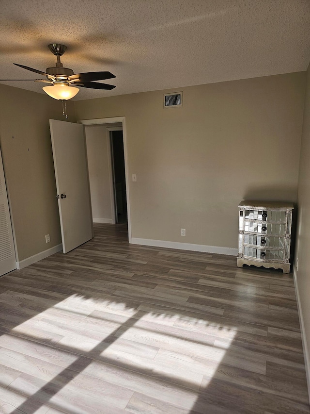 unfurnished bedroom with a textured ceiling, ceiling fan, and hardwood / wood-style floors