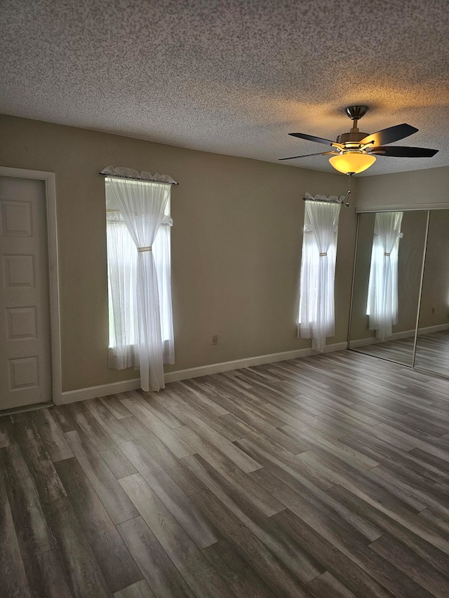 empty room featuring dark hardwood / wood-style floors, a textured ceiling, and ceiling fan