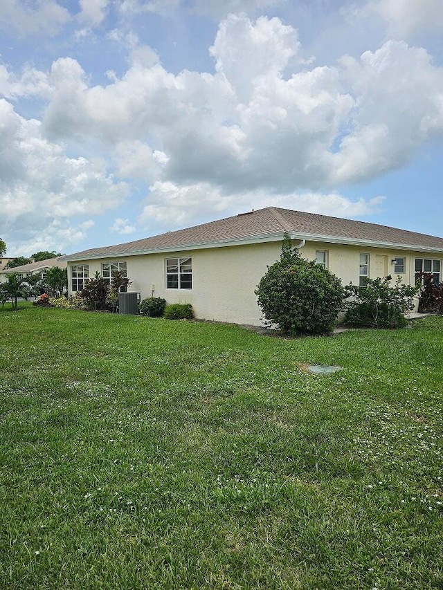 view of home's exterior featuring cooling unit and a lawn