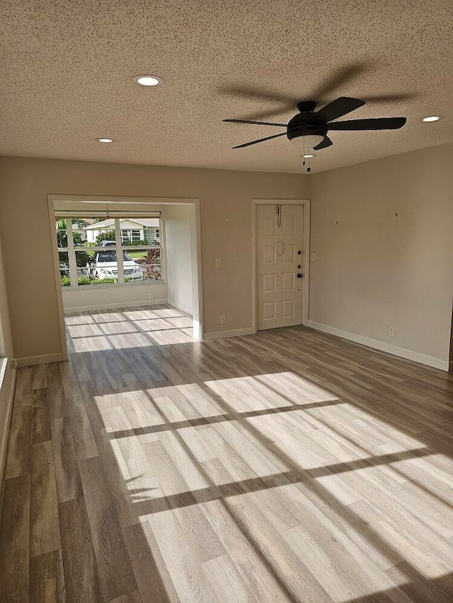 spare room with a textured ceiling, ceiling fan, and hardwood / wood-style floors