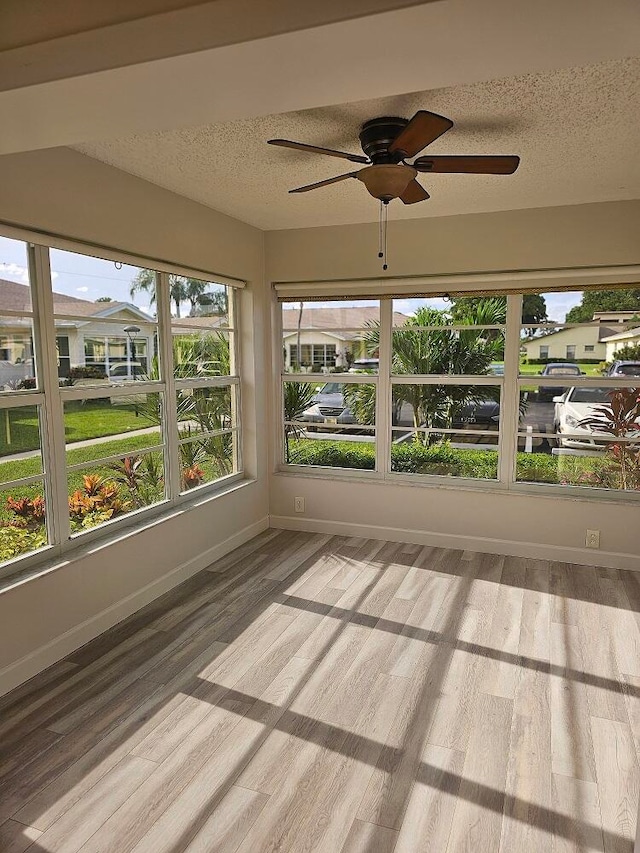 unfurnished sunroom with ceiling fan