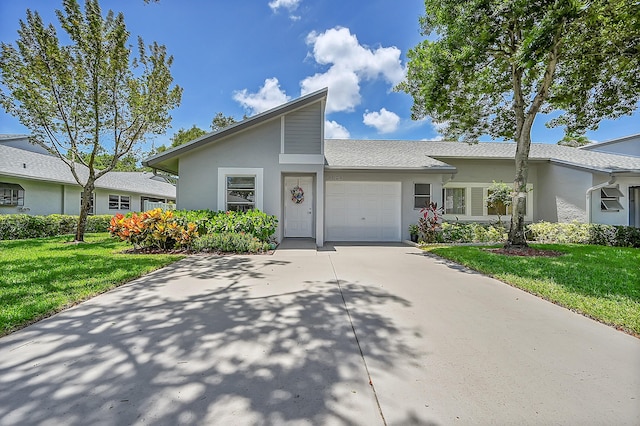 view of front of house featuring concrete driveway, an attached garage, a front lawn, and stucco siding