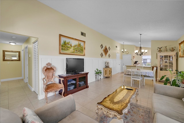 living room featuring a notable chandelier, light tile patterned flooring, and a textured ceiling