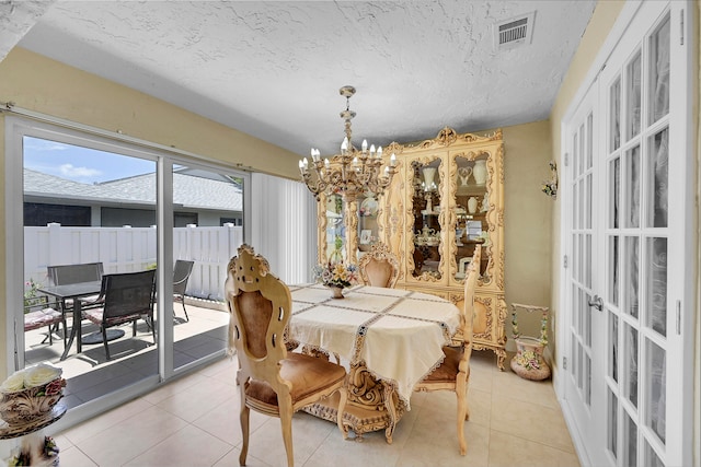 tiled dining area featuring a chandelier and a textured ceiling