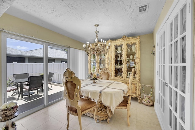 dining space featuring visible vents, a chandelier, a textured ceiling, french doors, and light tile patterned flooring
