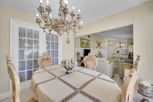 dining room featuring a chandelier, tile patterned flooring, baseboards, and a textured wall