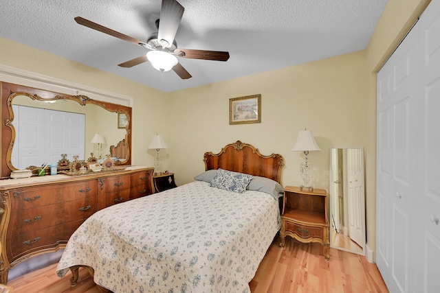 bedroom featuring a closet, a textured ceiling, ceiling fan, and light wood-type flooring