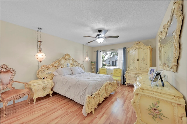 bedroom featuring a textured ceiling, light hardwood / wood-style flooring, and ceiling fan