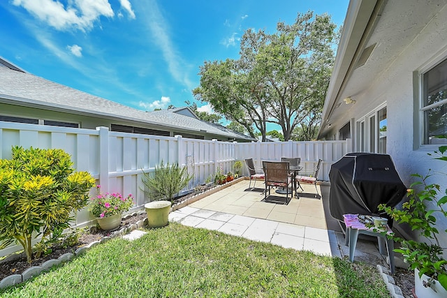 view of patio with a fenced backyard, outdoor dining space, and grilling area
