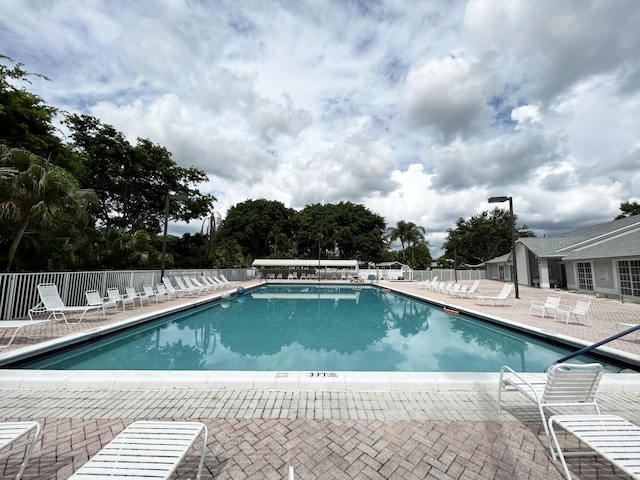community pool featuring a patio and fence