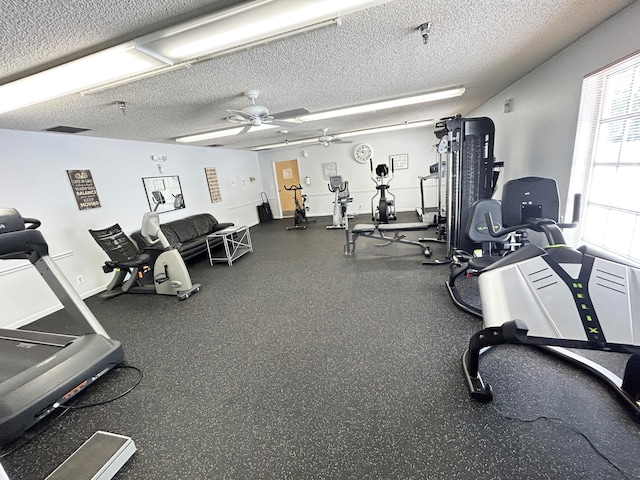 gym featuring a textured ceiling and ceiling fan