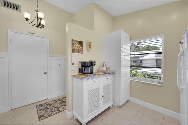 kitchen with visible vents, white cabinets, light tile patterned floors, a notable chandelier, and light countertops
