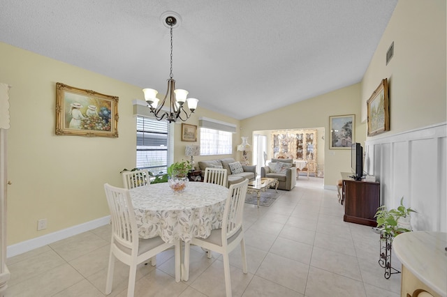 dining area with an inviting chandelier, light tile patterned floors, a textured ceiling, vaulted ceiling, and visible vents