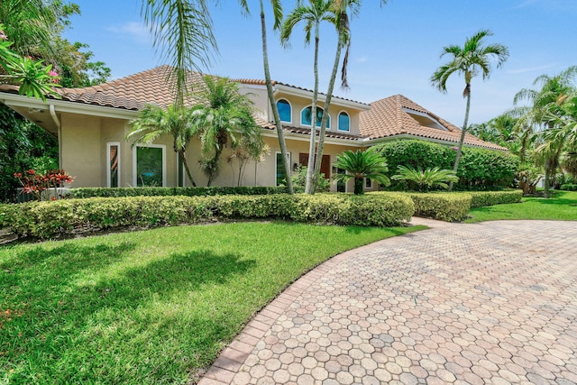 mediterranean / spanish home with a front yard