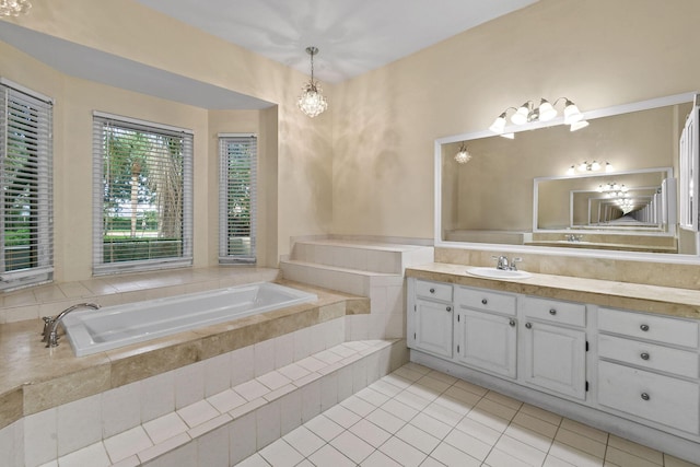 bathroom featuring an inviting chandelier, tile patterned floors, tiled bath, and vanity