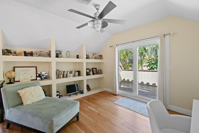 living area with lofted ceiling, built in shelves, ceiling fan, and hardwood / wood-style flooring