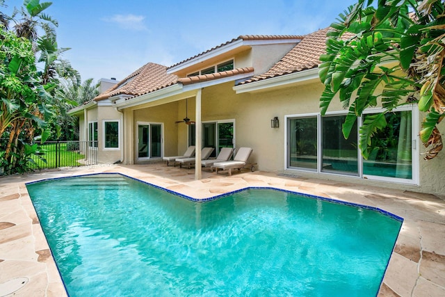 back of property featuring a fenced in pool, ceiling fan, and a patio area