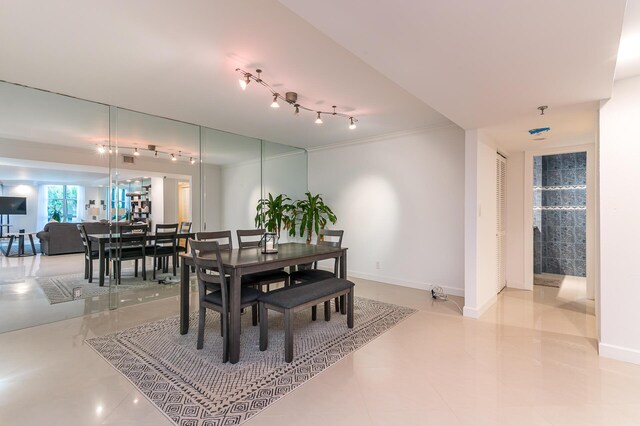 dining area with crown molding and light tile patterned floors