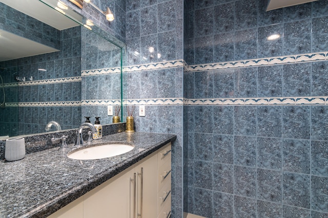 bathroom with vanity and tile walls