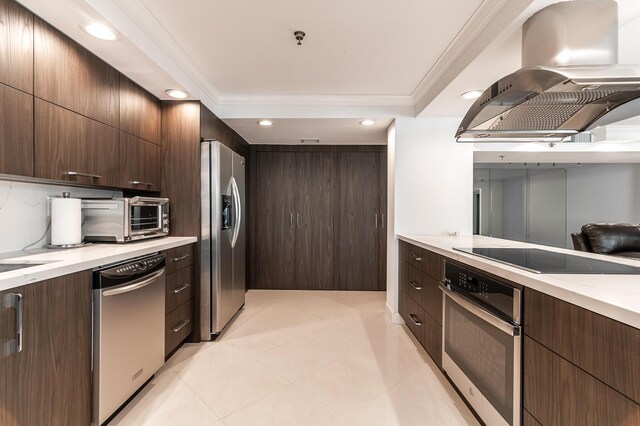 kitchen featuring appliances with stainless steel finishes, dark brown cabinetry, island range hood, and crown molding