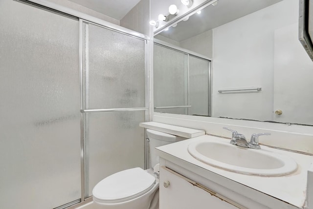 bathroom featuring vanity, an enclosed shower, and toilet