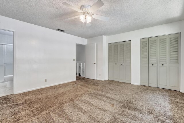 unfurnished bedroom featuring ensuite bath, carpet, ceiling fan, and a textured ceiling