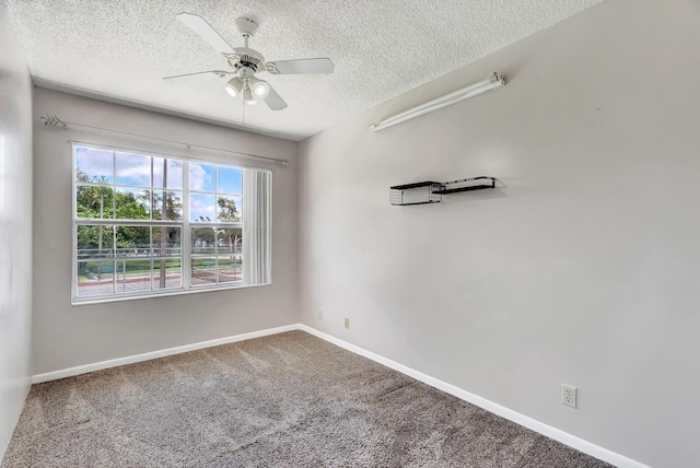 spare room featuring a textured ceiling, ceiling fan, carpet flooring, and baseboards