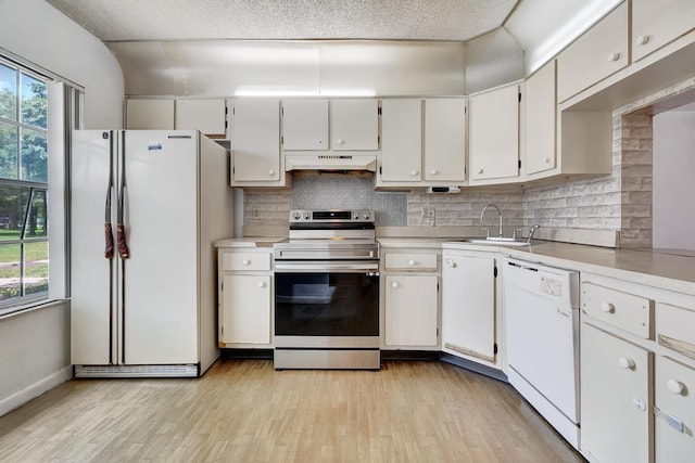 kitchen with white appliances, a sink, and white cabinets