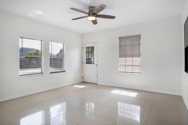 spare room featuring ceiling fan and light tile patterned floors