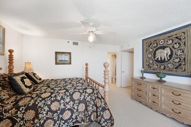 bedroom featuring a textured ceiling, ceiling fan, and light colored carpet