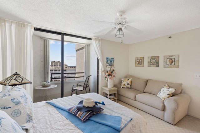 bedroom with carpet flooring, a textured ceiling, ceiling fan, and access to exterior