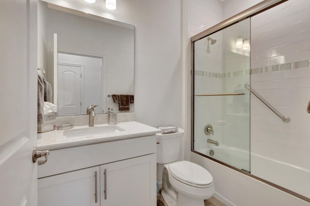 full bathroom with shower / bath combination with glass door, vanity, and toilet