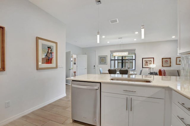 kitchen featuring white cabinetry, sink, hanging light fixtures, stainless steel dishwasher, and a notable chandelier