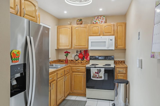 kitchen with sink, light tile patterned flooring, white appliances, and light brown cabinets