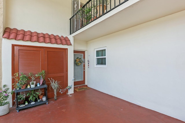 view of exterior entry featuring a balcony