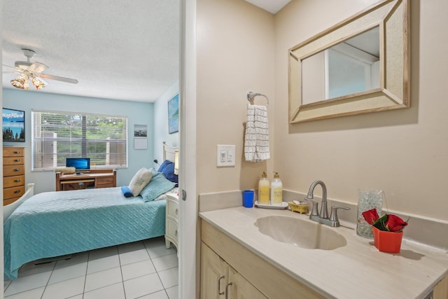 bathroom with tile patterned floors, vanity, ceiling fan, and a textured ceiling