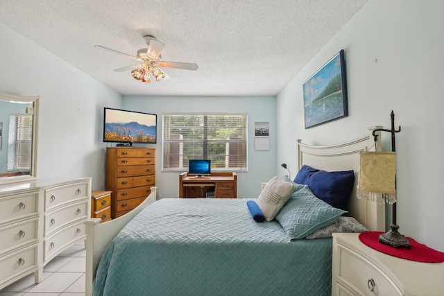 tiled bedroom featuring ceiling fan and a textured ceiling