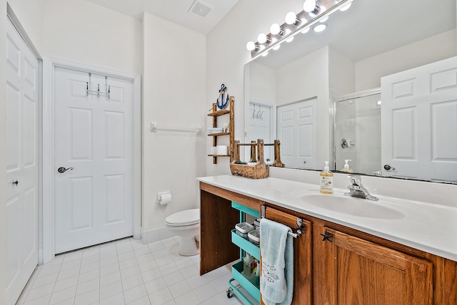 bathroom with toilet, tile patterned flooring, walk in shower, and vanity