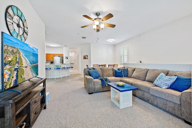 carpeted living room featuring ceiling fan