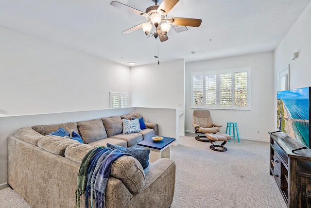 carpeted living room with ceiling fan and a textured ceiling