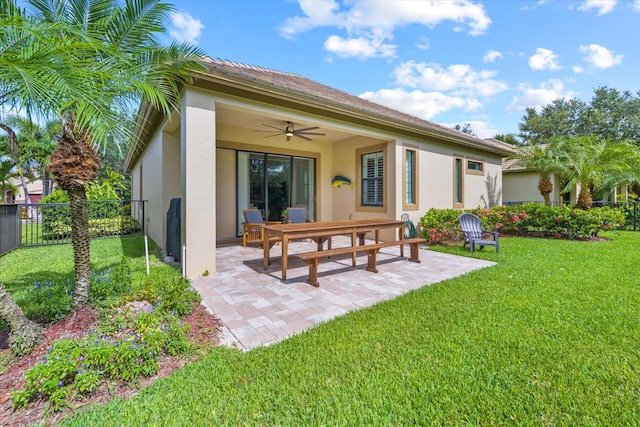 rear view of property with a yard, ceiling fan, and a patio area