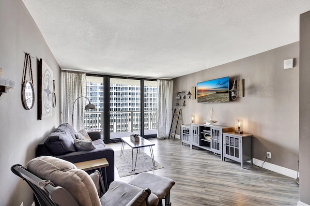 living room with hardwood / wood-style flooring, expansive windows, and a textured ceiling