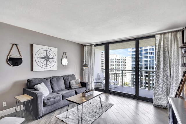 living room featuring hardwood / wood-style floors, floor to ceiling windows, a textured ceiling, and a wealth of natural light