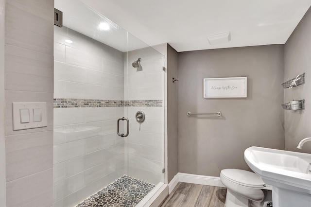 bathroom featuring sink, wood-type flooring, an enclosed shower, and toilet