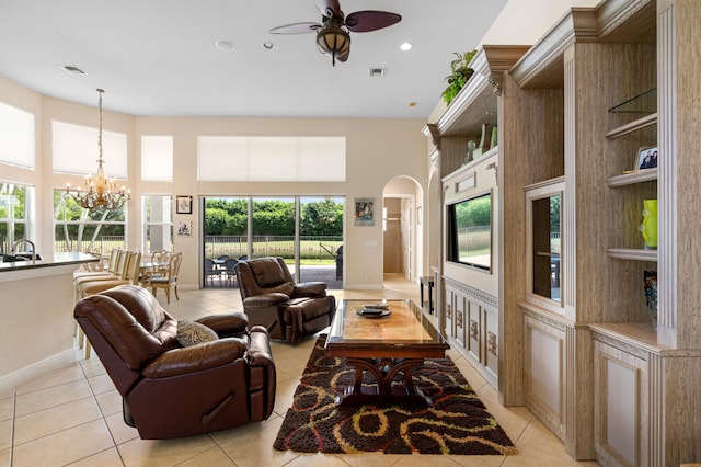 tiled living room with ceiling fan with notable chandelier and sink